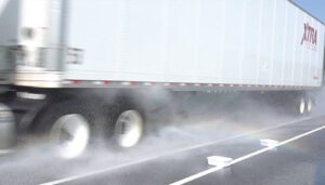 side view of a semi-trailer showing the spray pattern with conventional spray flaps